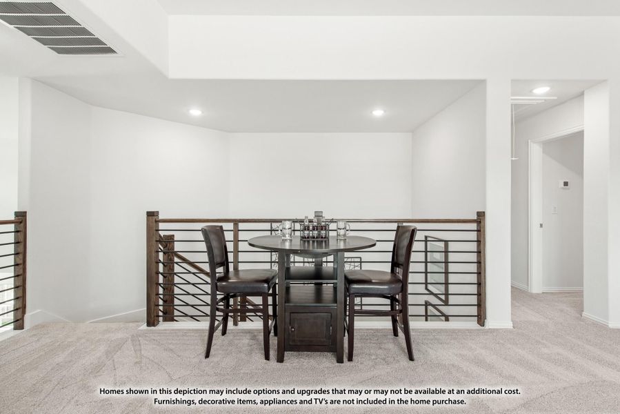 Loft area with round pub-height table, dark chairs, metal railing, and carpet flooring Loft area with round pub-height table, dark chairs, metal railing, and carpet flooring