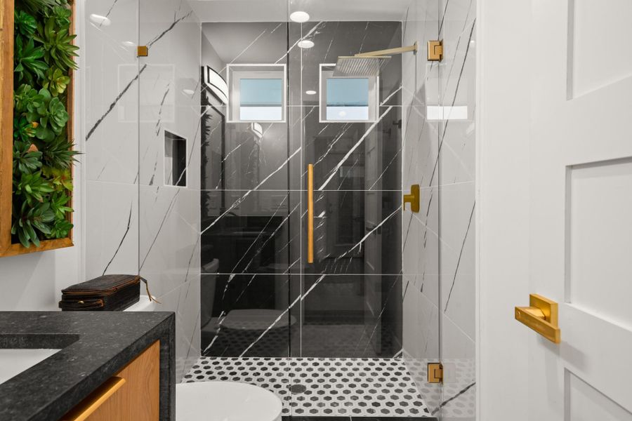 Primary bathroom featuring a marble finish shower and vanity