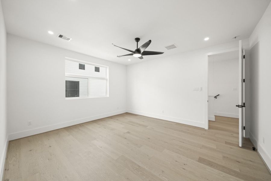A view of the owner's bedroom with access to the hallway. A built in study nook and the utility room are located outside the owner’s suite .