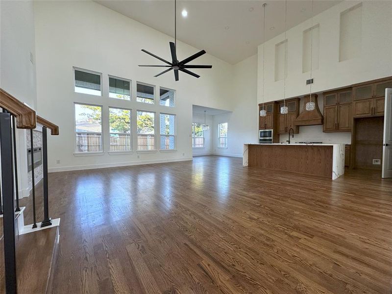 Unfurnished living room with dark hardwood / wood-style flooring, sink, and ceiling fan