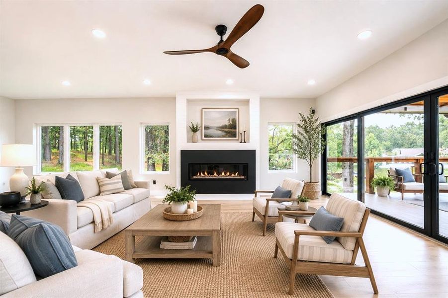 Virtually staged-Spacious living area featuring light wood-finish flooring, a contemporary fireplace with a dark surround, and large windows Virtually staged-Spacious living area featuring light wood-finish flooring, a contemporary fireplace with a dark surround, and large windows
