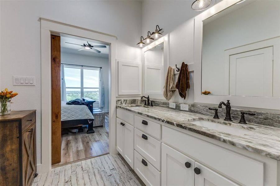 Bathroom featuring ceiling fan, double sink vanity, and hardwood / wood-style floors Bathroom featuring ceiling fan, double sink vanity, and hardwood / wood-style floors
