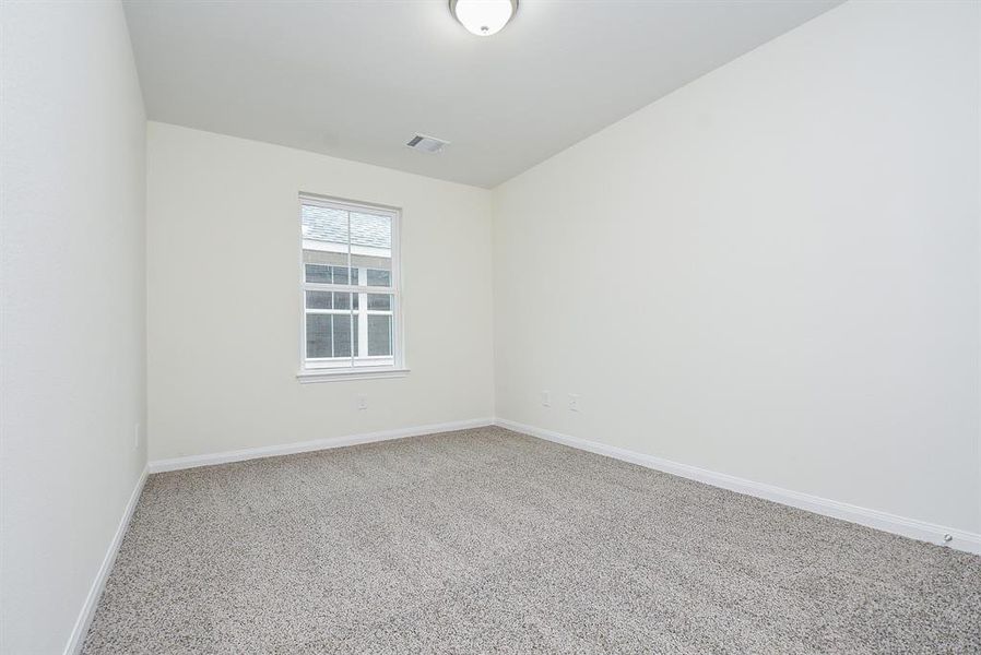 Empty room with beige walls, carpeted floor, and a single window.