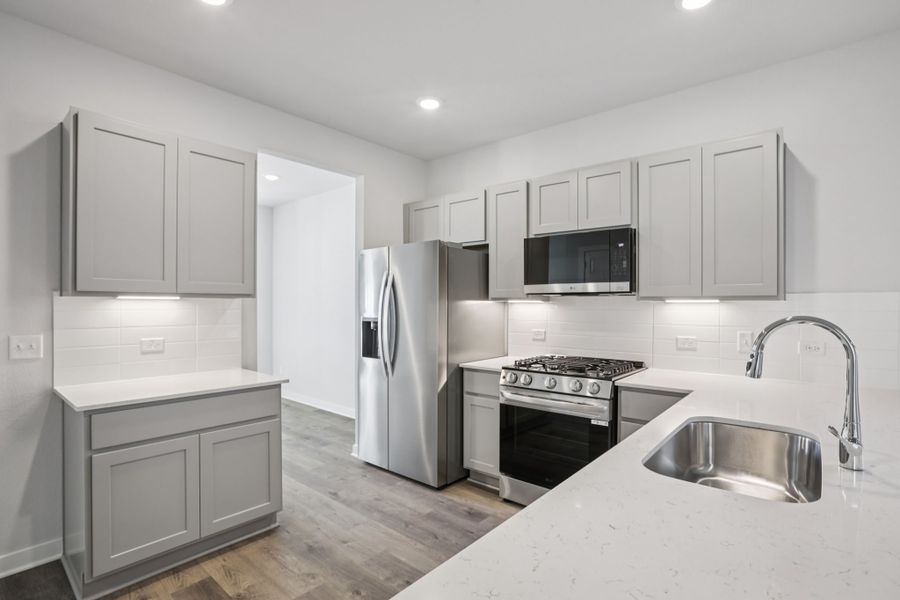 A kitchen with white cabinets.