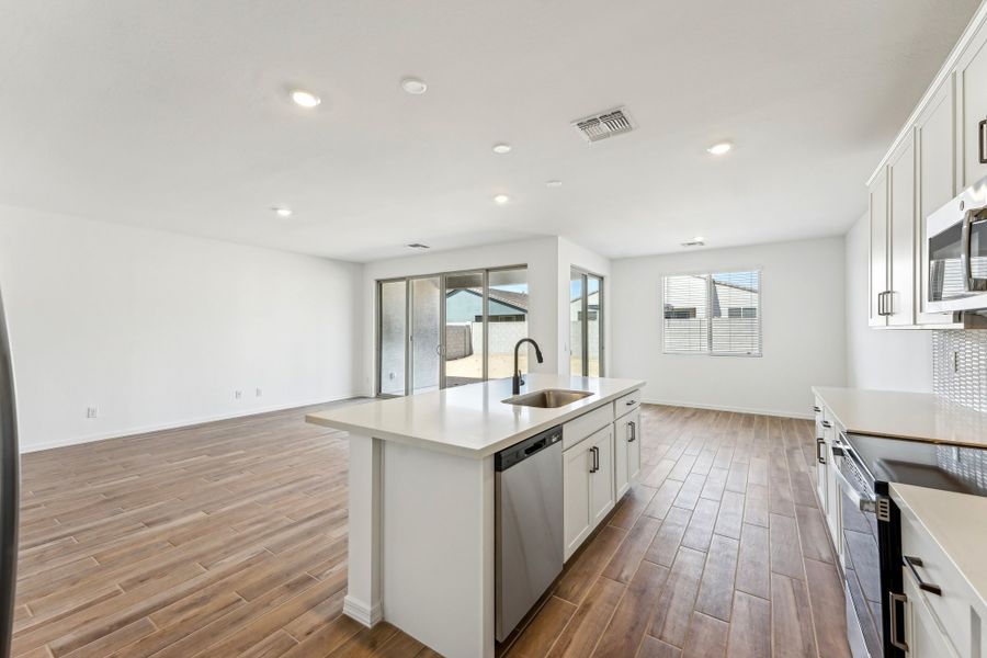 Great room, kitchen and dining. Finishes vary by community