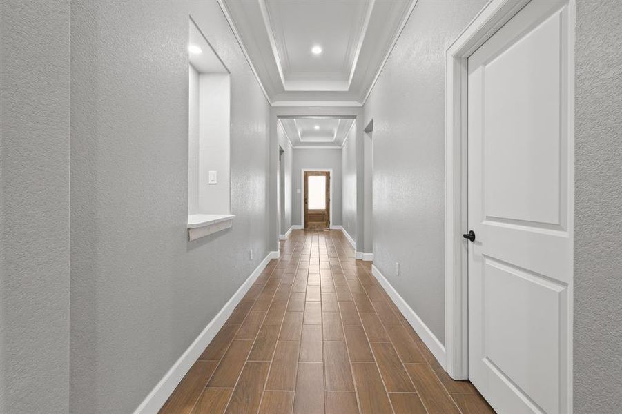 Corridor featuring wood-type flooring and crown molding