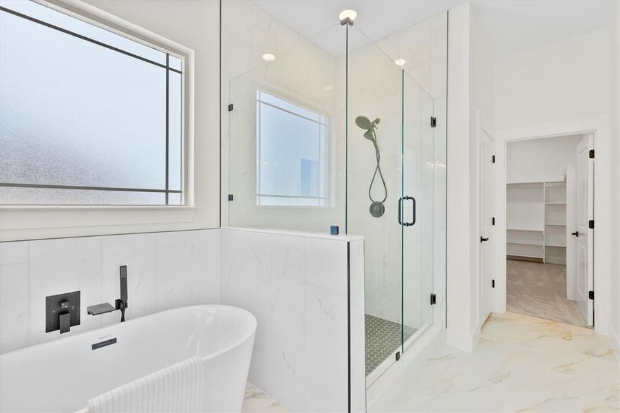 Bathroom featuring marble tiled flooring, a marble finish shower, a soaking tub, and a walk in closet Bathroom featuring marble tiled flooring, a marble finish shower, a soaking tub, and a walk in closet