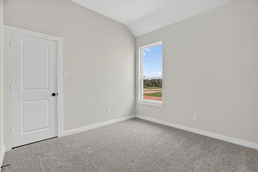 Secondary bedroom with light gray walls, white trim, and gray speckled carpeting