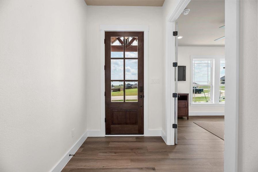 Doorway featuring wood finished floors and baseboards Doorway featuring wood finished floors and baseboards