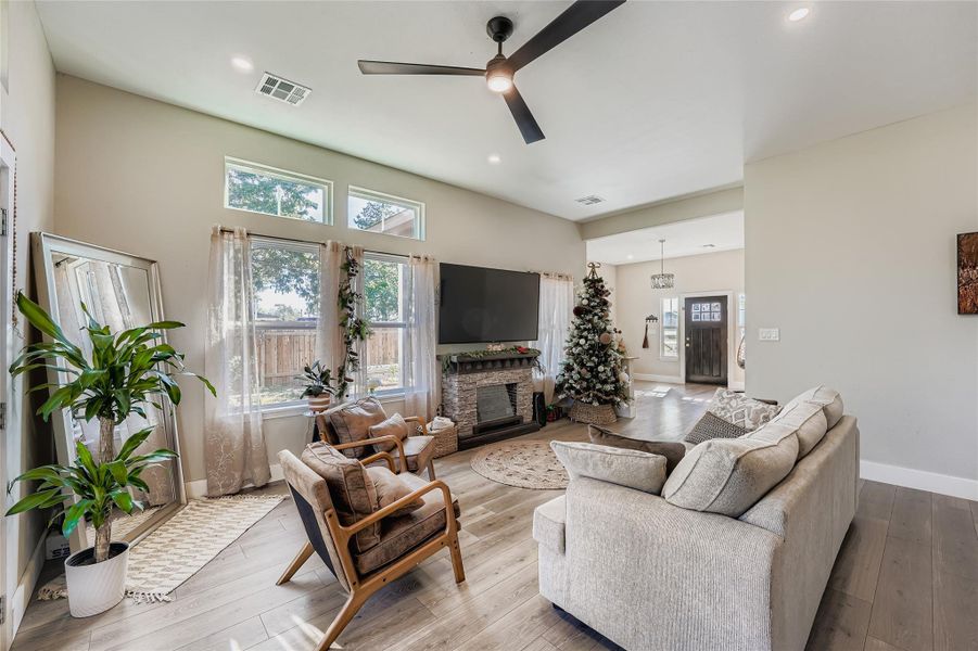 Living area featuring plenty of natural light, a fireplace, hardwood / wood-style flooring, and recessed lighting Living area featuring plenty of natural light, a fireplace, hardwood / wood-style flooring, and recessed lighting