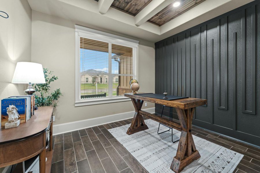 Modern office space featuring a distinctive dark accent wall with vertical paneling, wood-finish flooring, and a coffered ceiling with a rustic wood-look inlay