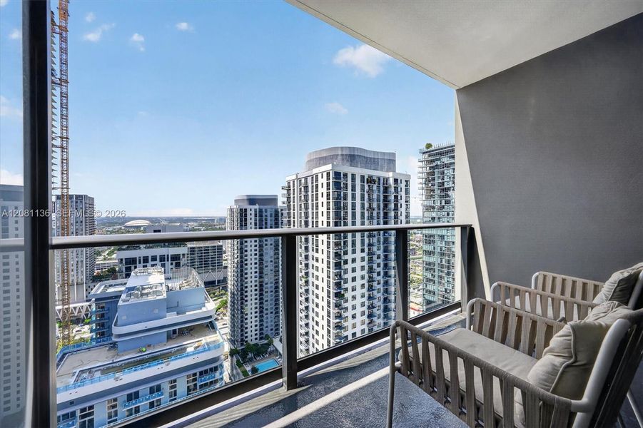 Private balcony featuring a dark-toned floor surface and a modern glass-panel railing