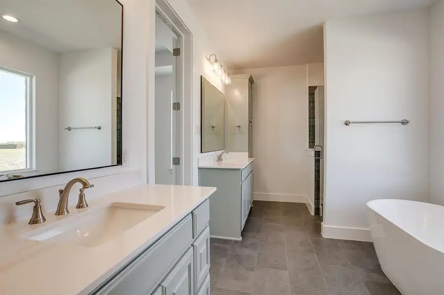 Full bathroom featuring a freestanding tub, two vanities, and a shower stall Full bathroom featuring a freestanding tub, two vanities, and a shower stall