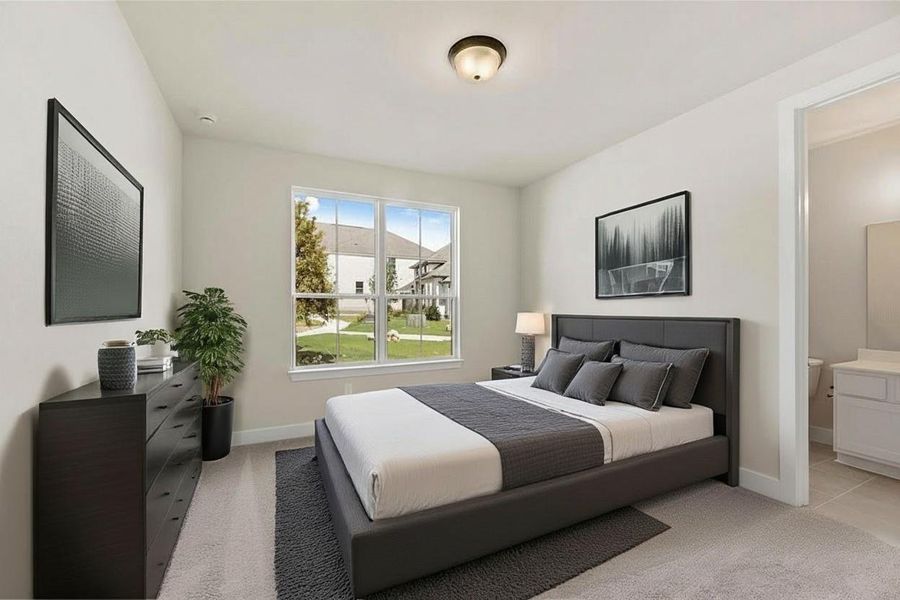 Bedroom featuring light colored carpet and ensuite bathroom