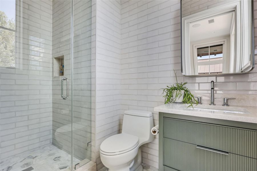 A refined bathroom featuring a contemporary vanity and a spacious glass-enclosed shower.
