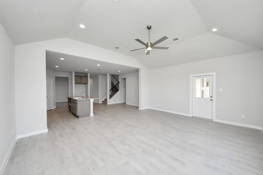 Gather the family and guests together in your lovely living room! Featuring soaring high ceilings, recessed lighting, ceiling fan, custom paint, gorgeous floors, and large windows that provide plenty of natural lighting throughout the day. Sample photo of completed home with similar floor plan. Actual colors and selections may vary.