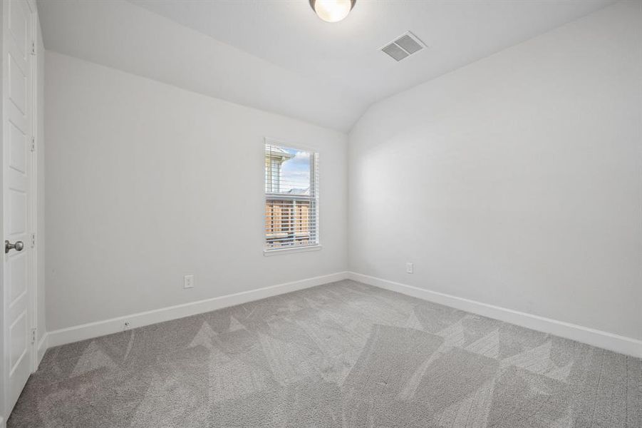 Room featuring light gray patterned carpeting, white painted walls, a single window with horizontal blinds, a white paneled door, and a flush-mount ceiling light fixture