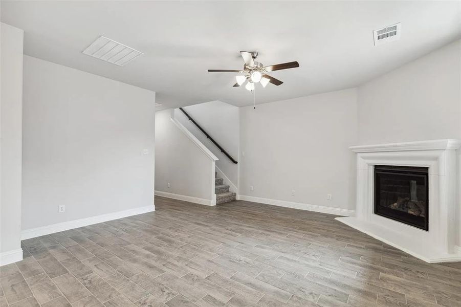 Unfurnished living room with ceiling fan and light hardwood / wood-style flooring