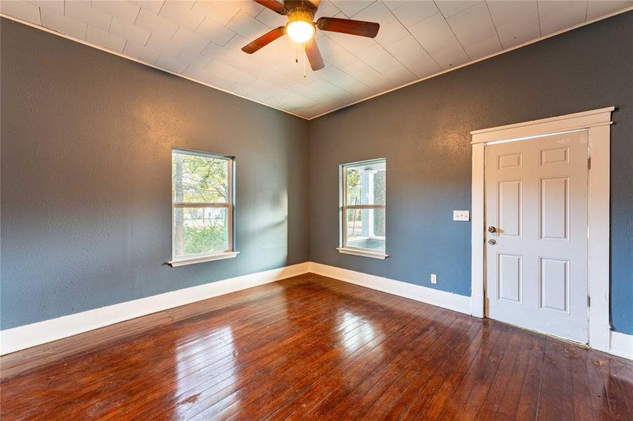 Unfurnished room with plenty of natural light, ceiling fan, wood-type flooring, and crown molding Unfurnished room with plenty of natural light, ceiling fan, wood-type flooring, and crown molding