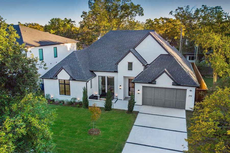 View of front of home with roof with shingles, concrete driveway, a front lawn, a garage, and stucco siding View of front of home with roof with shingles, concrete driveway, a front lawn, a garage, and stucco siding