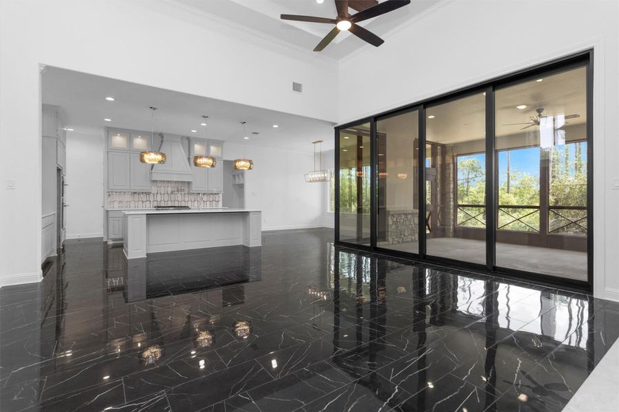 This expansive great room flows effortlessly into the designer kitchen with chic black tile flooring complemented by light cabinetry and finishes. This expansive great room flows effortlessly into the designer kitchen with chic black tile flooring complemented by light cabinetry and finishes.