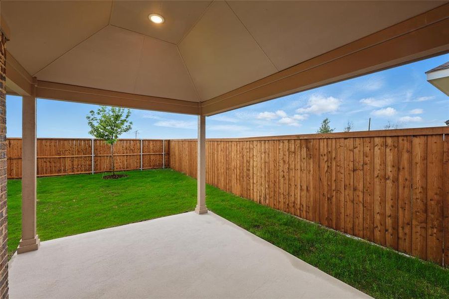 Fenced backyard with a patio area Fenced backyard with a patio area