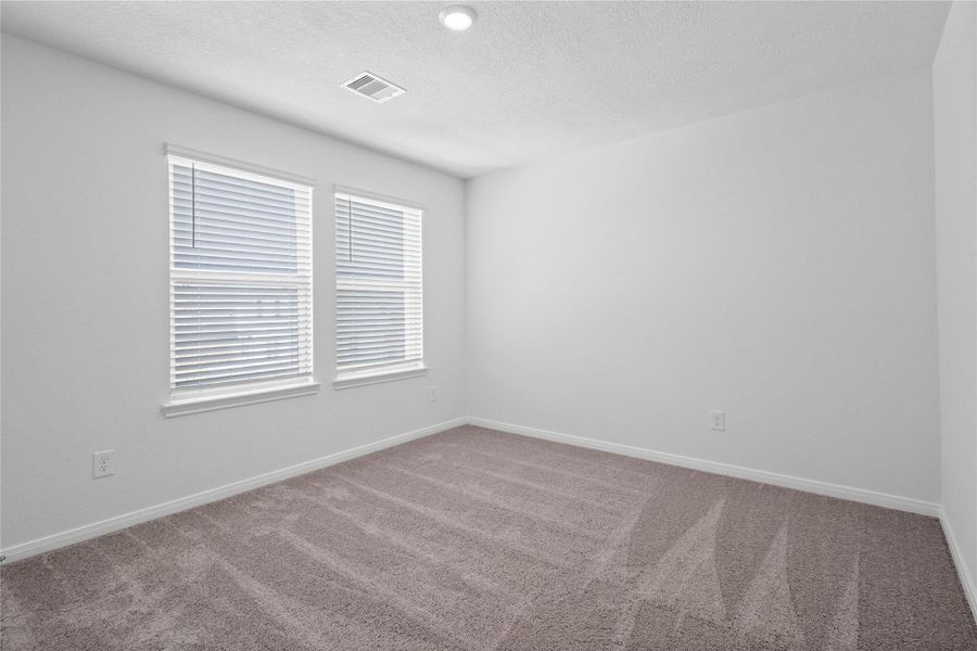 This secondary bedroom offers comfort and style with plush carpeting, neutral paint tones, recessed lighting, large windows with blinds, and a generously sized closet. This secondary bedroom offers comfort and style with plush carpeting, neutral paint tones, recessed lighting, large windows with blinds, and a generously sized closet.