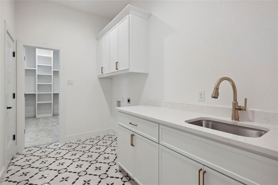 Laundry room with cabinets, hookup for an electric dryer, and sink