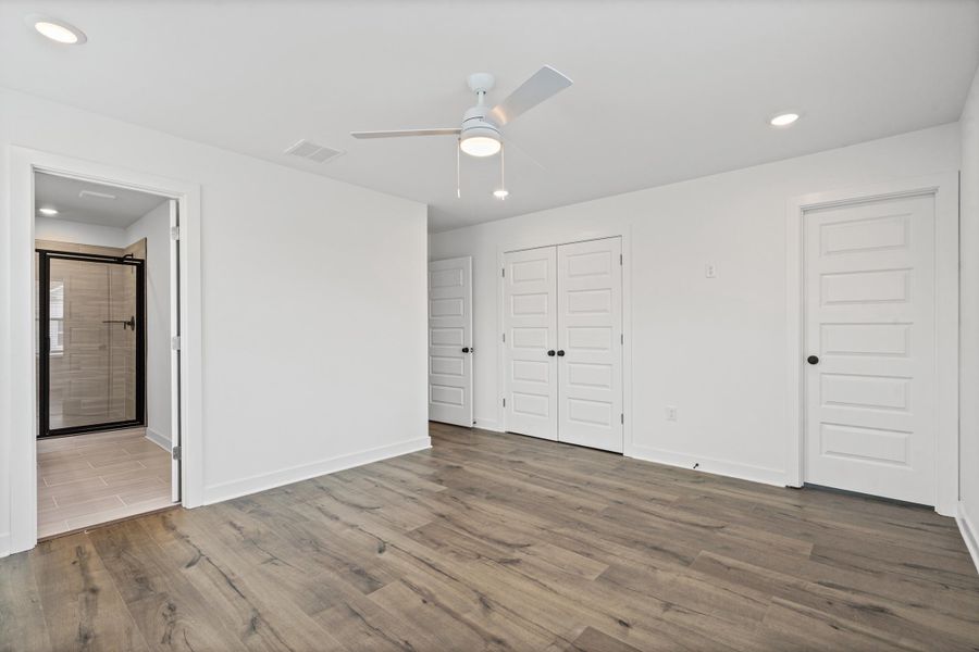 Spacious room featuring wood-finish flooring, recessed lighting, and a ceiling fan