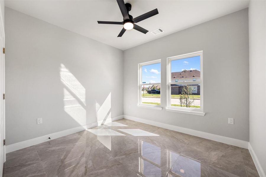 Unfurnished room featuring marble tiled floors and a ceiling fan