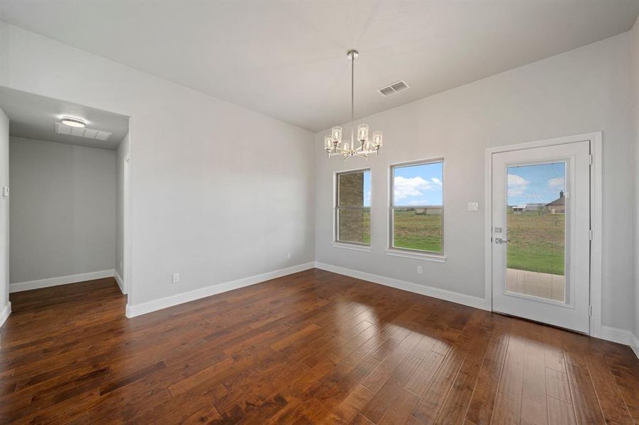 Unfurnished dining area featuring dark hardwood / wood-style flooring and a chandelier