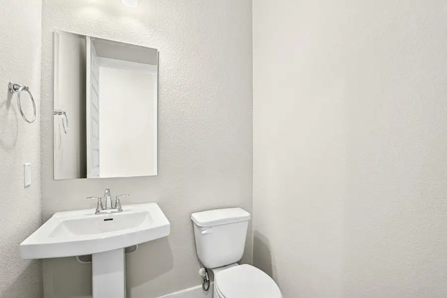 Half bath featuring a textured wall and toilet Half bath featuring a textured wall and toilet