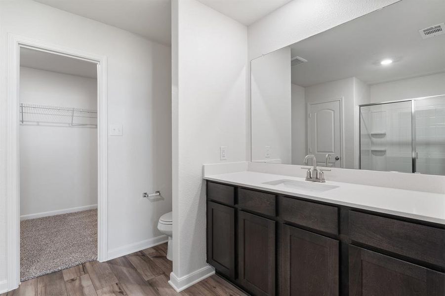 Bathroom featuring wood-type flooring, oversized vanity, and toilet