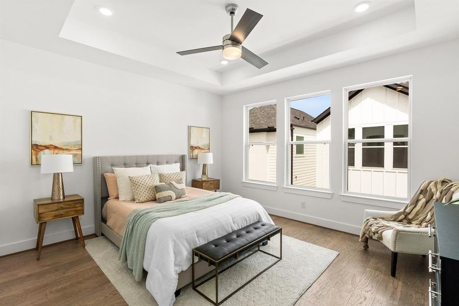 The primary bedroom comes fully equipped with tray ceilings and oversized windows.