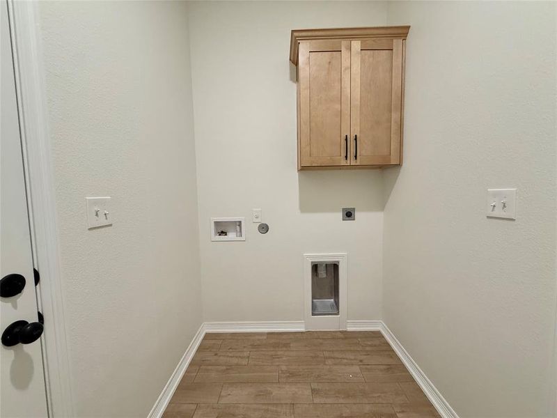 Laundry room featuring electric dryer hookup, gas dryer hookup, light wood-style flooring, cabinet space, and hookup for a washing machine