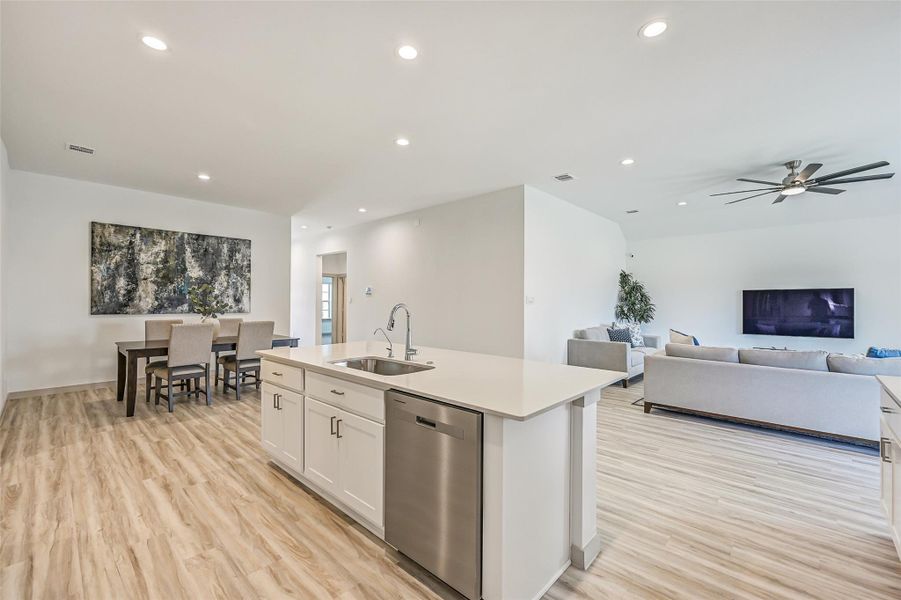 This angle really showcases the home's open design, with the island kitchen positioned between the spacious dining and family rooms for effortless flow from one living space to the next. This angle really showcases the home's open design, with the island kitchen positioned between the spacious dining and family rooms for effortless flow from one living space to the next.