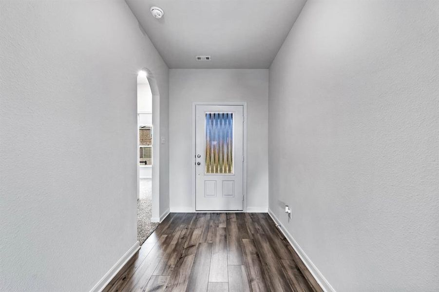 Doorway with dark wood-type flooring