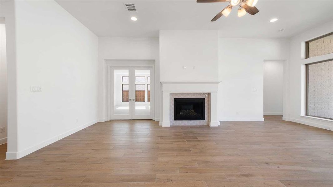 Unfurnished living room with ceiling fan and light wood-type flooring