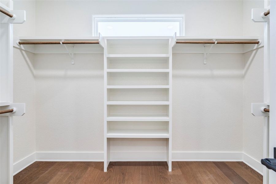 Spacious closet with dark wood-style floors