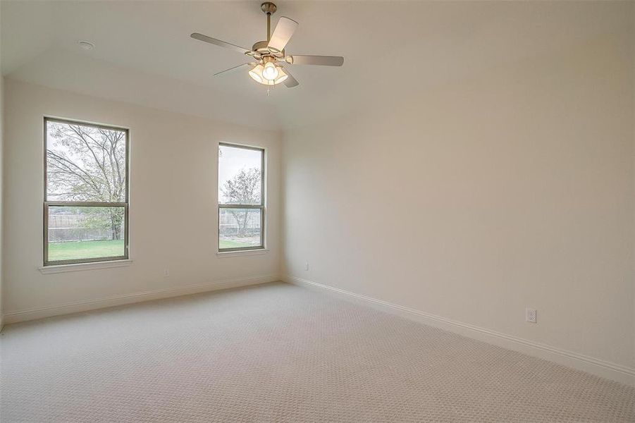 Carpeted empty room featuring ceiling fan