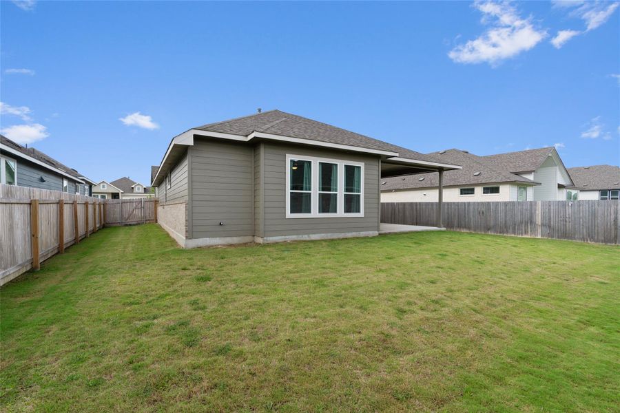 A well-maintained lawn provides ample space for outdoor activities, complementing the covered patio.
