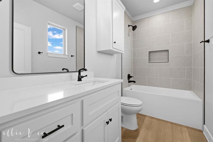 Bathroom featuring vanity, bathing tub / shower combination, and light wood-type flooring