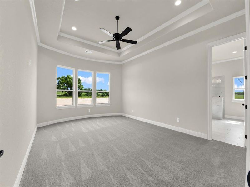 Spare room with a tray ceiling, carpet flooring, crown molding, ceiling fan, and recessed lighting Spare room with a tray ceiling, carpet flooring, crown molding, ceiling fan, and recessed lighting