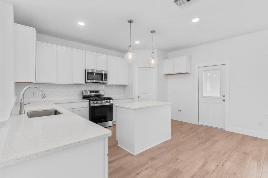 Another view of the gourmet kitchen highlighting the open layout and convenient backyard access. Another view of the gourmet kitchen highlighting the open layout and convenient backyard access.