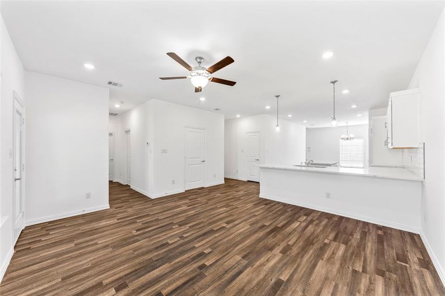 Unfurnished living room with ceiling fan, sink, and dark hardwood / wood-style flooring