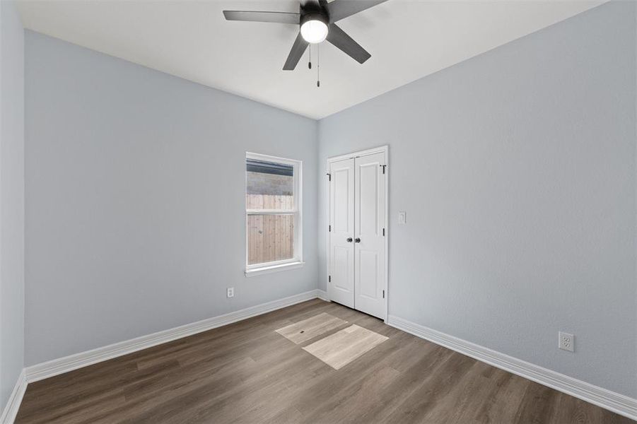 Unfurnished bedroom featuring wood finished floors, ceiling fan, and a closet