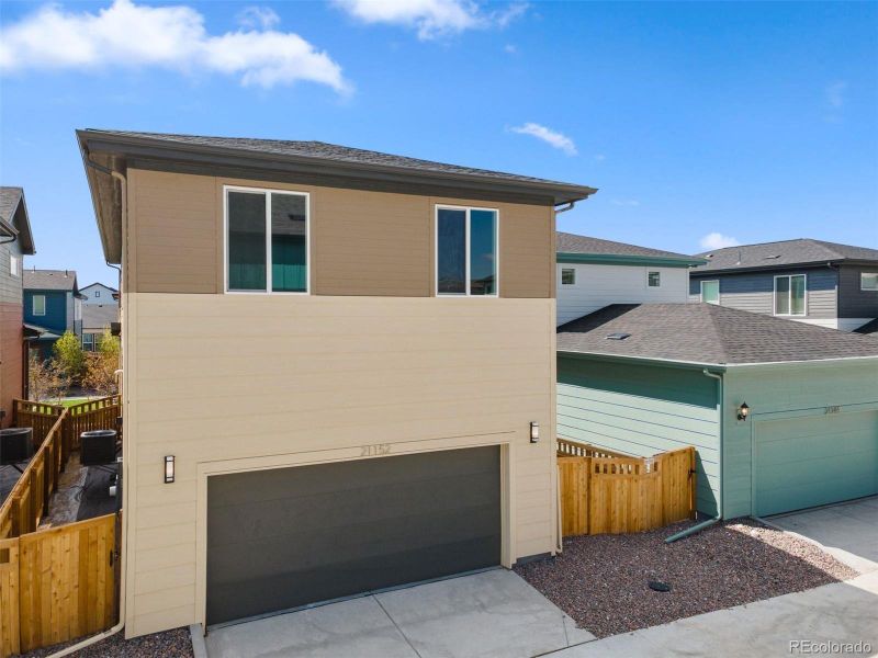 Front exterior of a new home in Woodrose at Painted Prairie, Aurora, CO, highlighting curb appeal (Image 21).