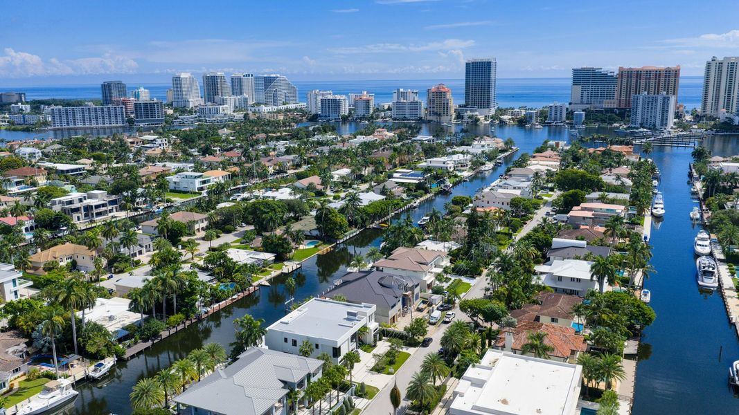 A vibrant neighborhood scene showing waterfront homes leading toward the Fort Lauderdale coastline and ocean horizon. A vibrant neighborhood scene showing waterfront homes leading toward the Fort Lauderdale coastline and ocean horizon.