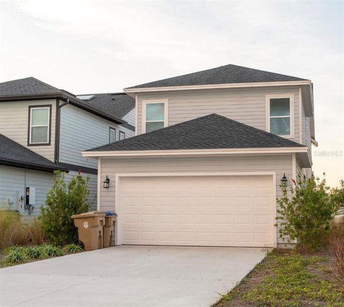 Front exterior of a new home in Weslyn Park in Sunbridge 34', St. Cloud, FL, highlighting curb appeal (Image 30).