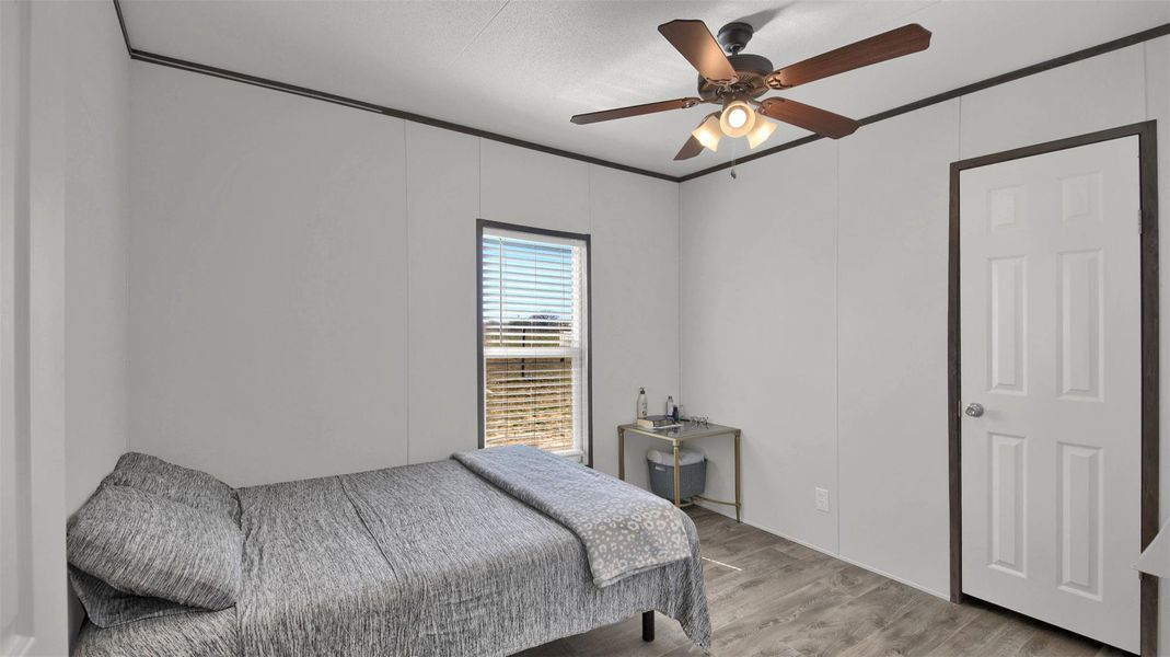 Bedroom with light wood-style floors and a ceiling fan